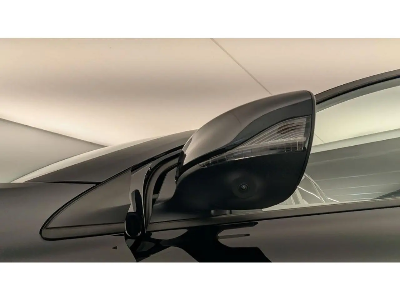 Gros plan sur le rétroviseur droit noir brillant du MG3 1.5 Hybrid+ 195 Luxury avec caméra intégrée.