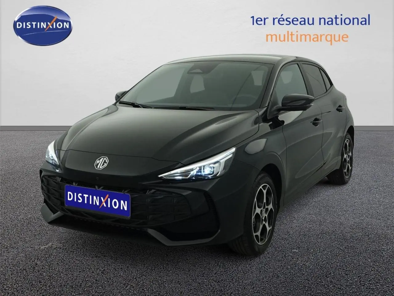 MG3 1.5 Hybrid+ noir métallisé vu en 3/4 avant droit avec phares allumés et jantes spécifiques.