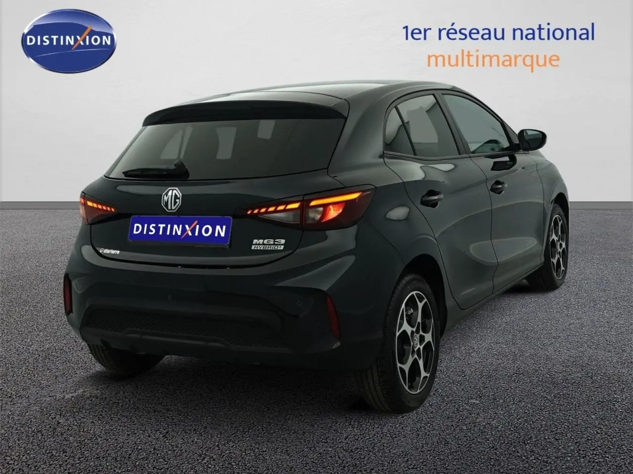 Vue 3/4 arrière droite d’une MG3 1.5 Hybrid+ noire avec feux arrière allumés et vitres surteintées.