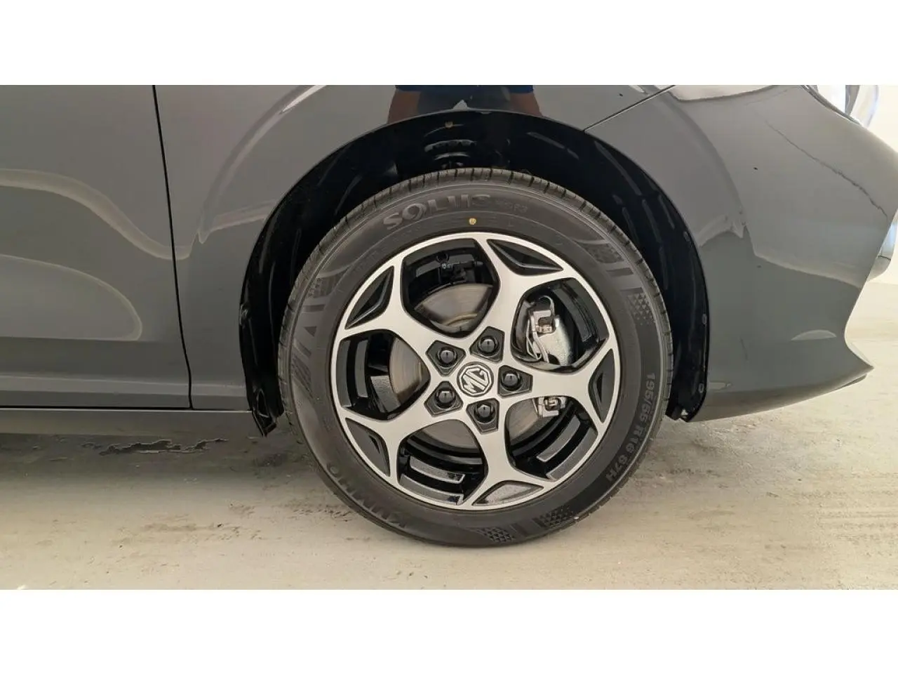 Gros plan sur la roue avant droite noire d'une MG3 1.5 Hybrid+ 195 Luxury avec jante alliage bicolore.