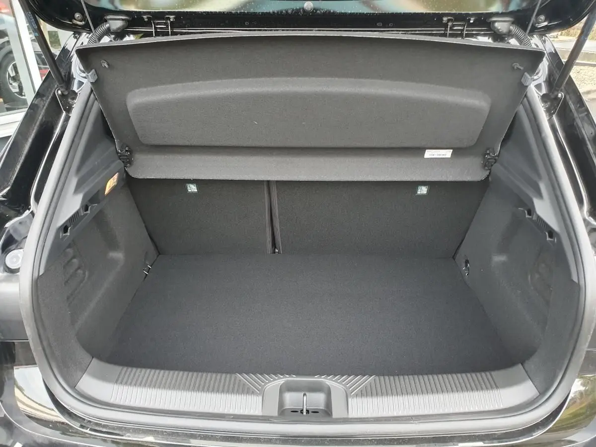 Coffre ouvert vu de l’arrière d’une Renault Clio VI noire étoile, montrant un espace de chargement vide et propre.