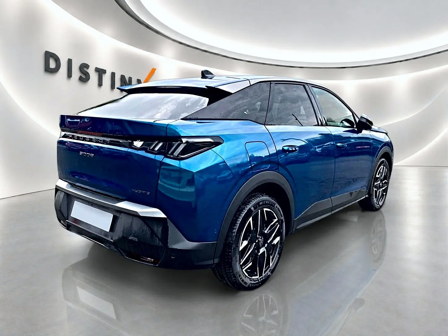 Vue 3/4 arrière droite d'un Peugeot 3008 bleu obsession avec jantes alliage et becquet arrière dans un showroom.