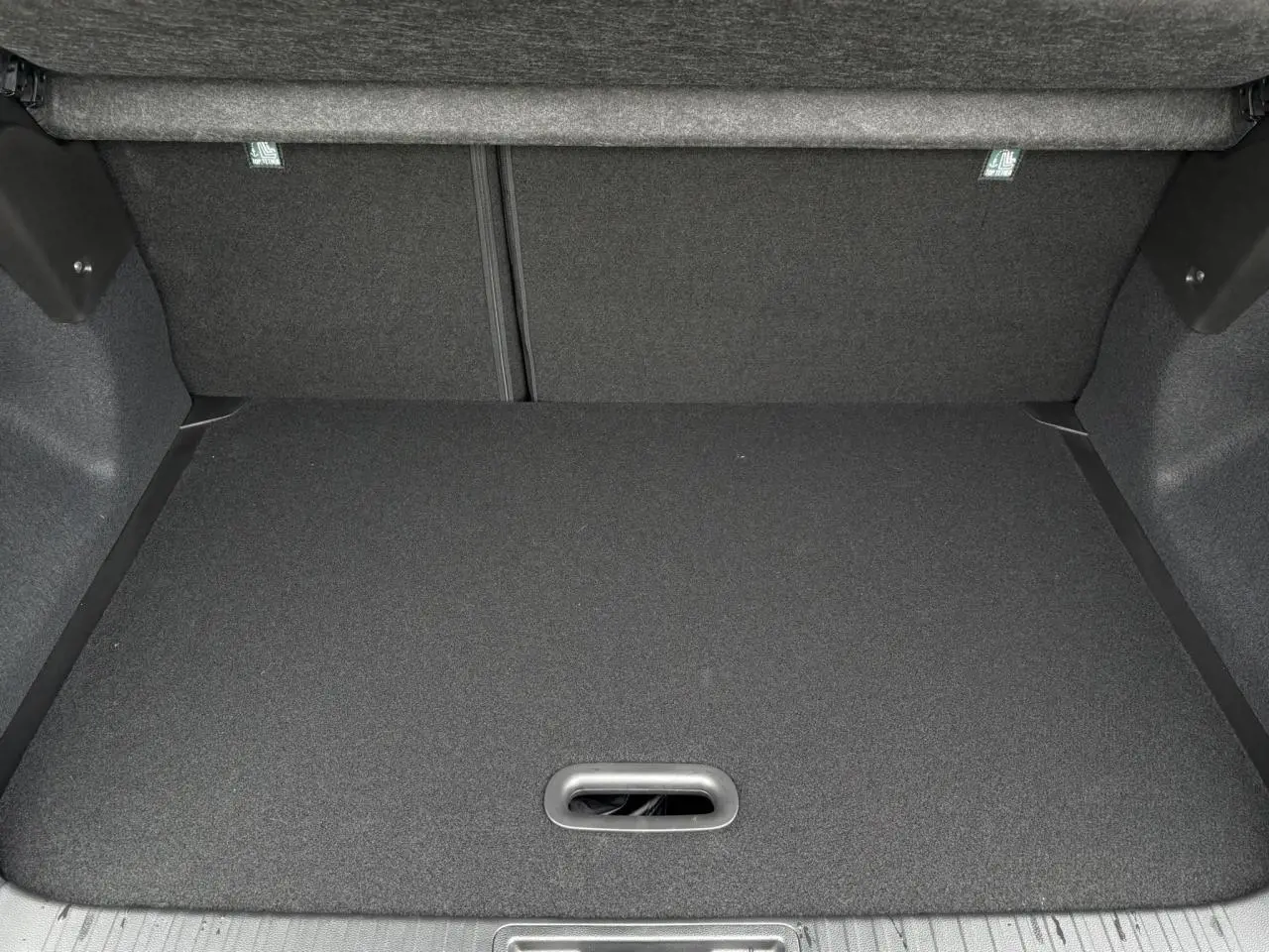 Coffre spacieux vu de face, revêtement noir et plancher plat du Renault Captur Noir Etoile 2025.