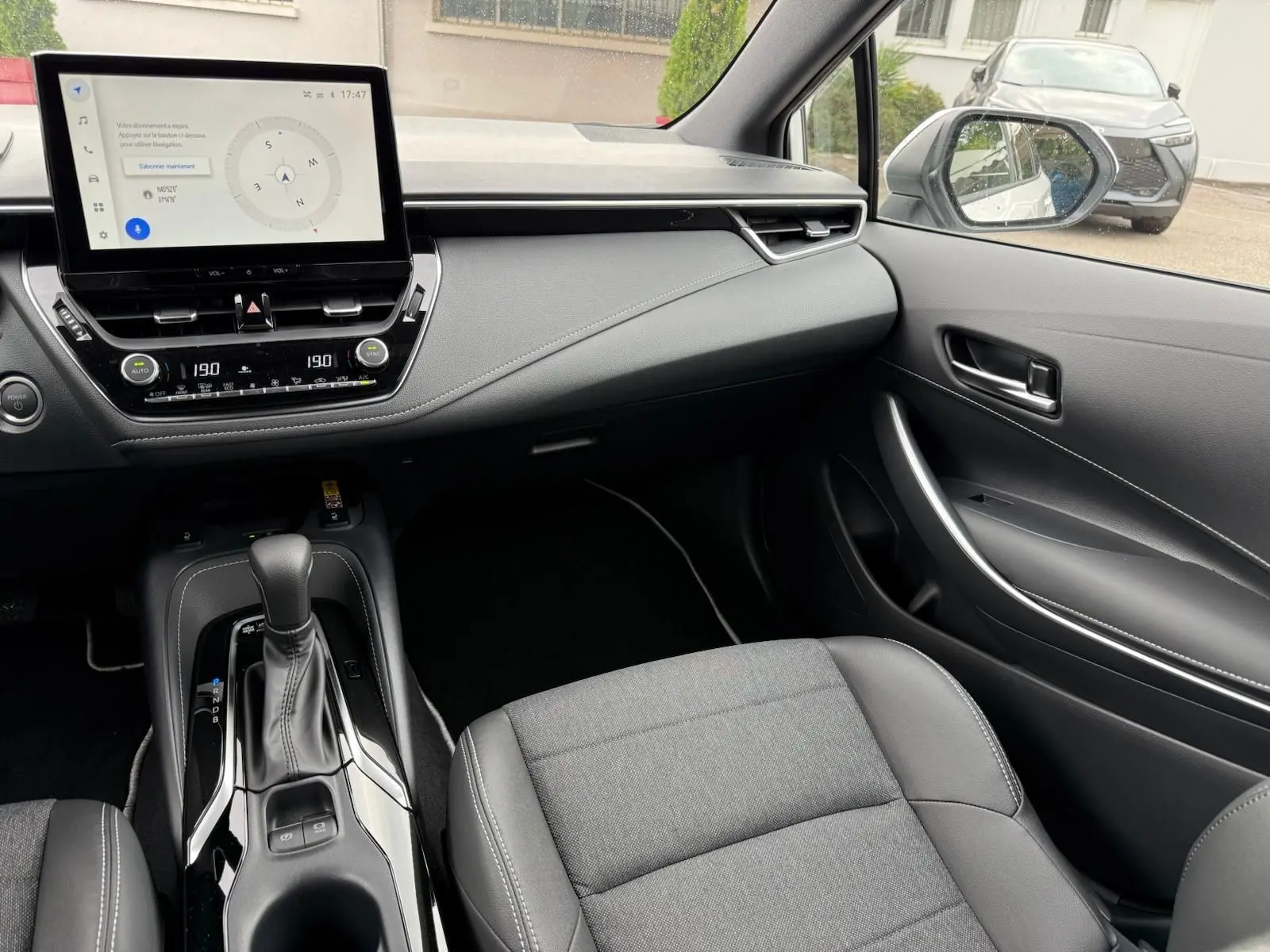 Intérieur de la Toyota Corolla Touring Sport 2025, vue côté passager, tableau de bord moderne et console centrale noire élégante.