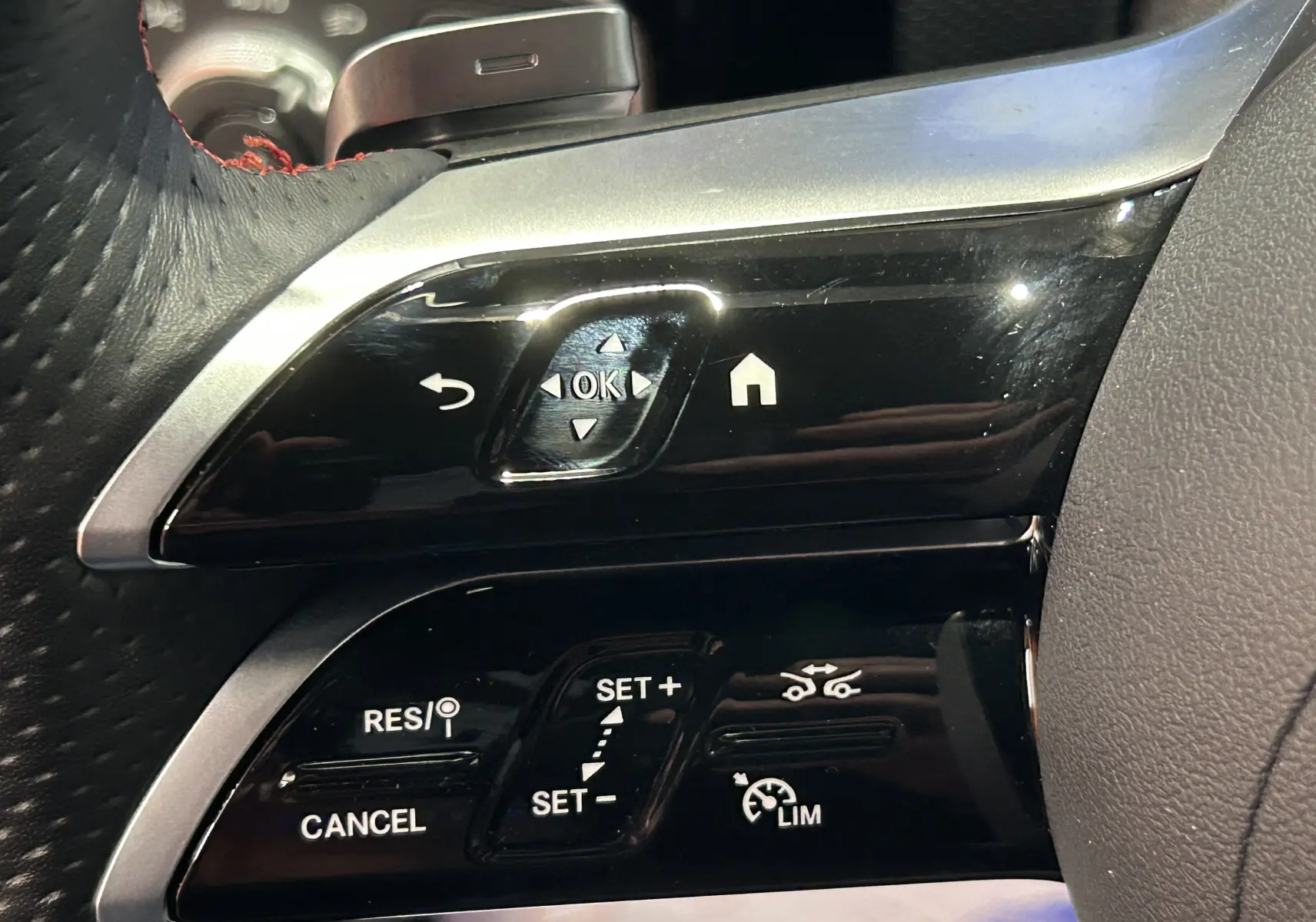 Gros plan sur les commandes noires du volant côté gauche du Mercedes Classe CLA Shooting Brake II 200D AMG 2024.