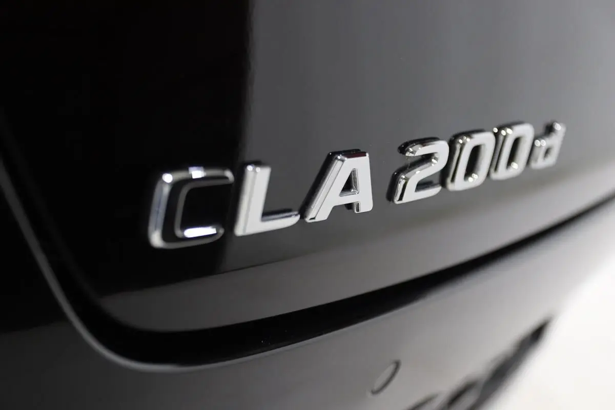Gros plan sur l'inscription CLA 200d argentée sur la carrosserie noire métallisée arrière du Mercedes CLA Shooting Brake.