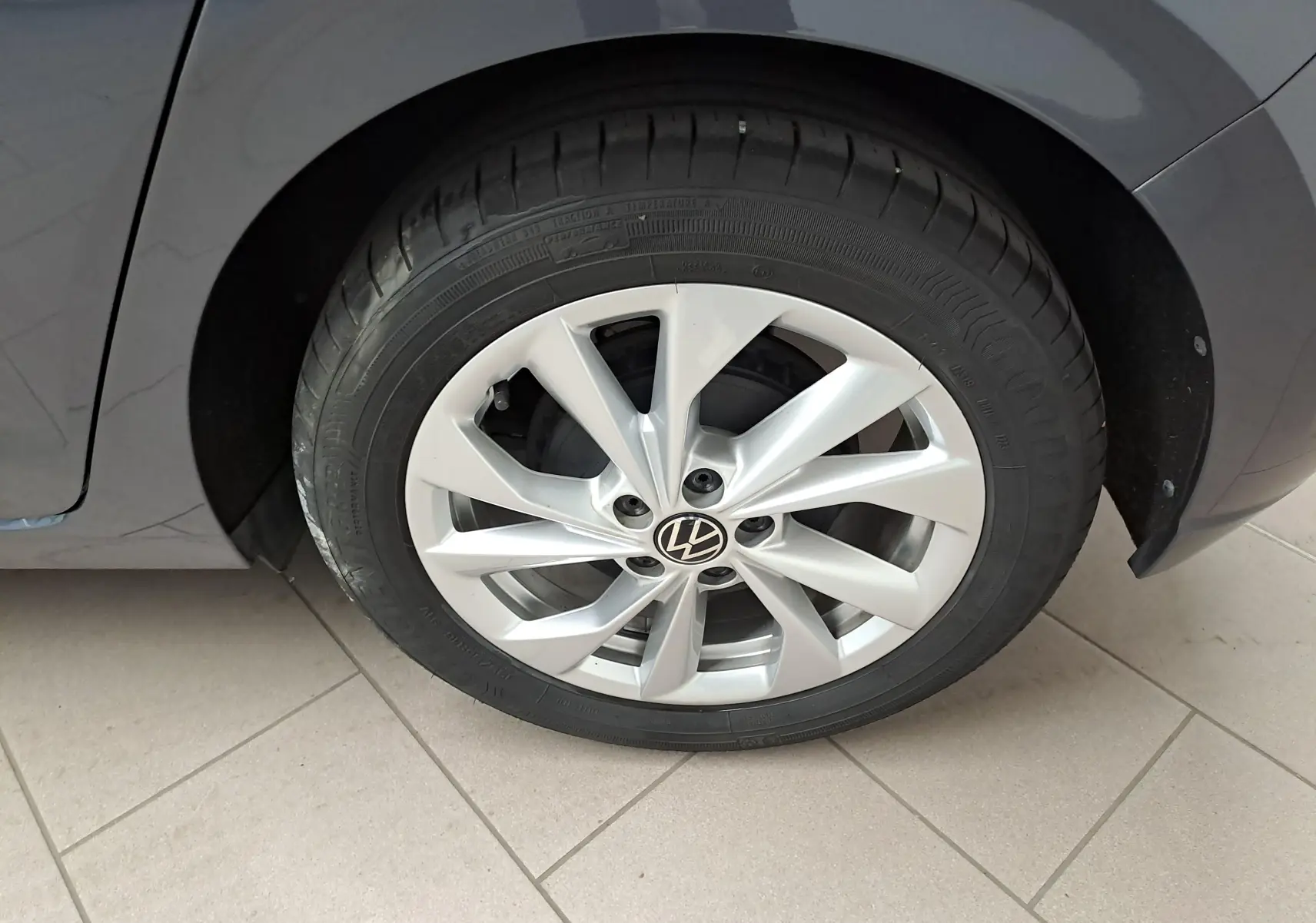 Gros plan sur la roue arrière droite d'une Volkswagen Polo gris cendré avec jante alliage et pneu Goodyear.
