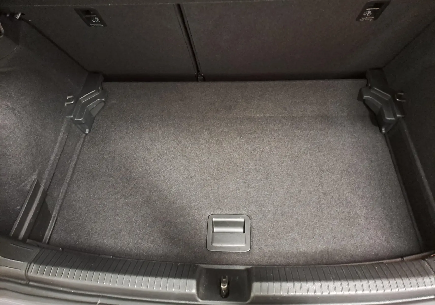 Coffre vide vu de dessus d'une Volkswagen Polo 2023 gris cendré avec tapis de sol gris foncé.