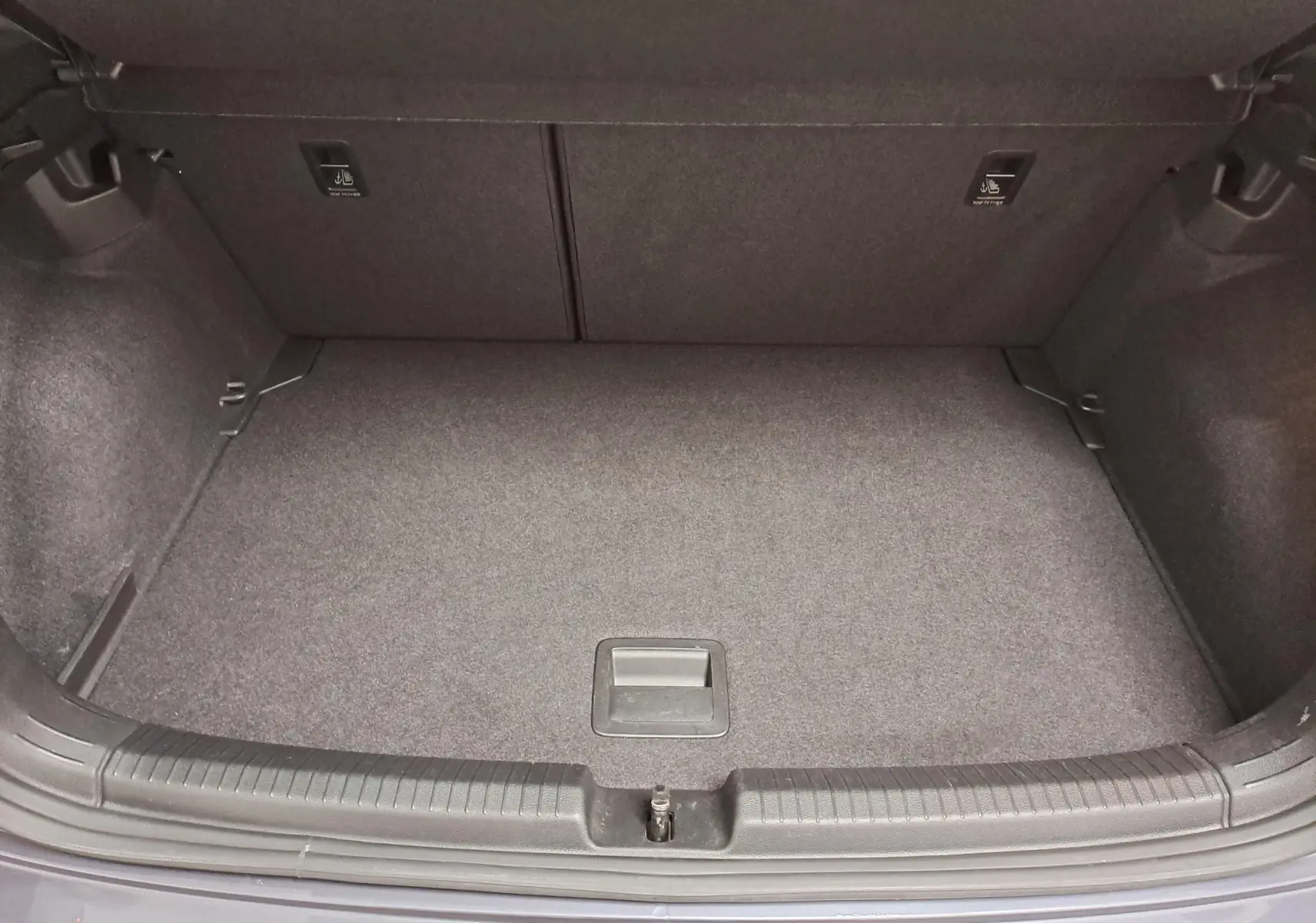 Coffre ouvert vu de dessus d’une Volkswagen Polo gris cendré 2023, montrant un espace de rangement propre et vide.