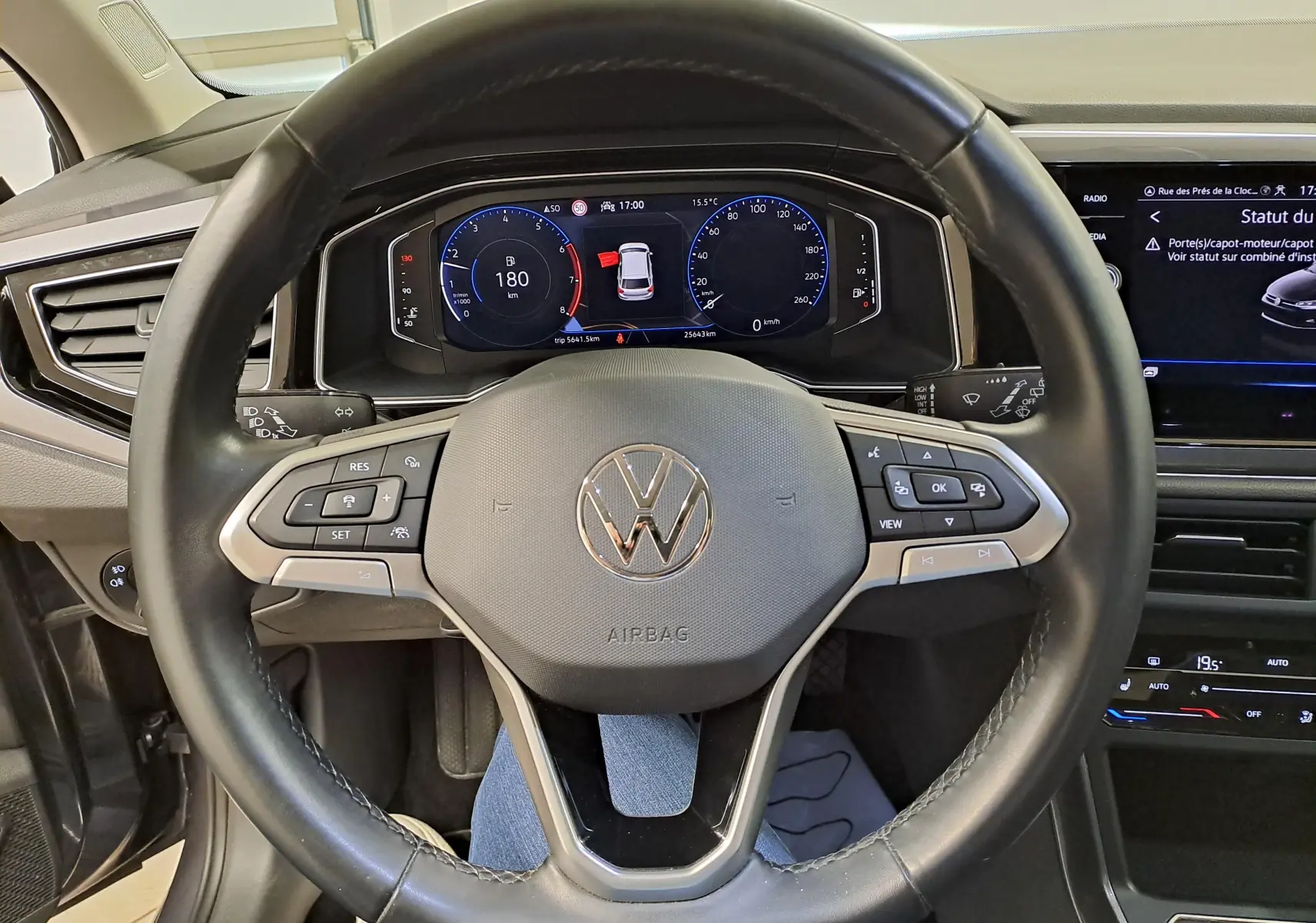 Vue intérieure centrée sur le volant noir de la Volkswagen Polo 2023 avec tableau de bord numérique et écran tactile.