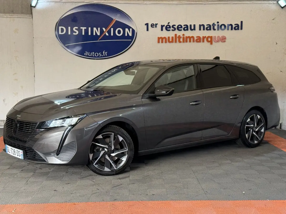 Peugeot 308 SW gris foncé vue de profil droit en intérieur, avec jantes alliage et feux LED distinctifs.