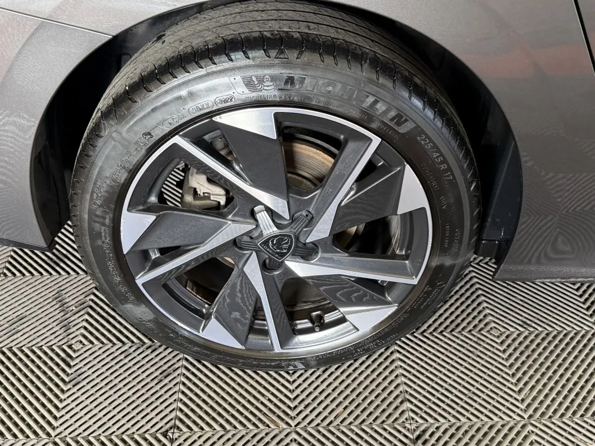 Gros plan sur la roue avant droite gris foncé d'une Peugeot 308 SW 2022 avec jante alliage au design moderne.