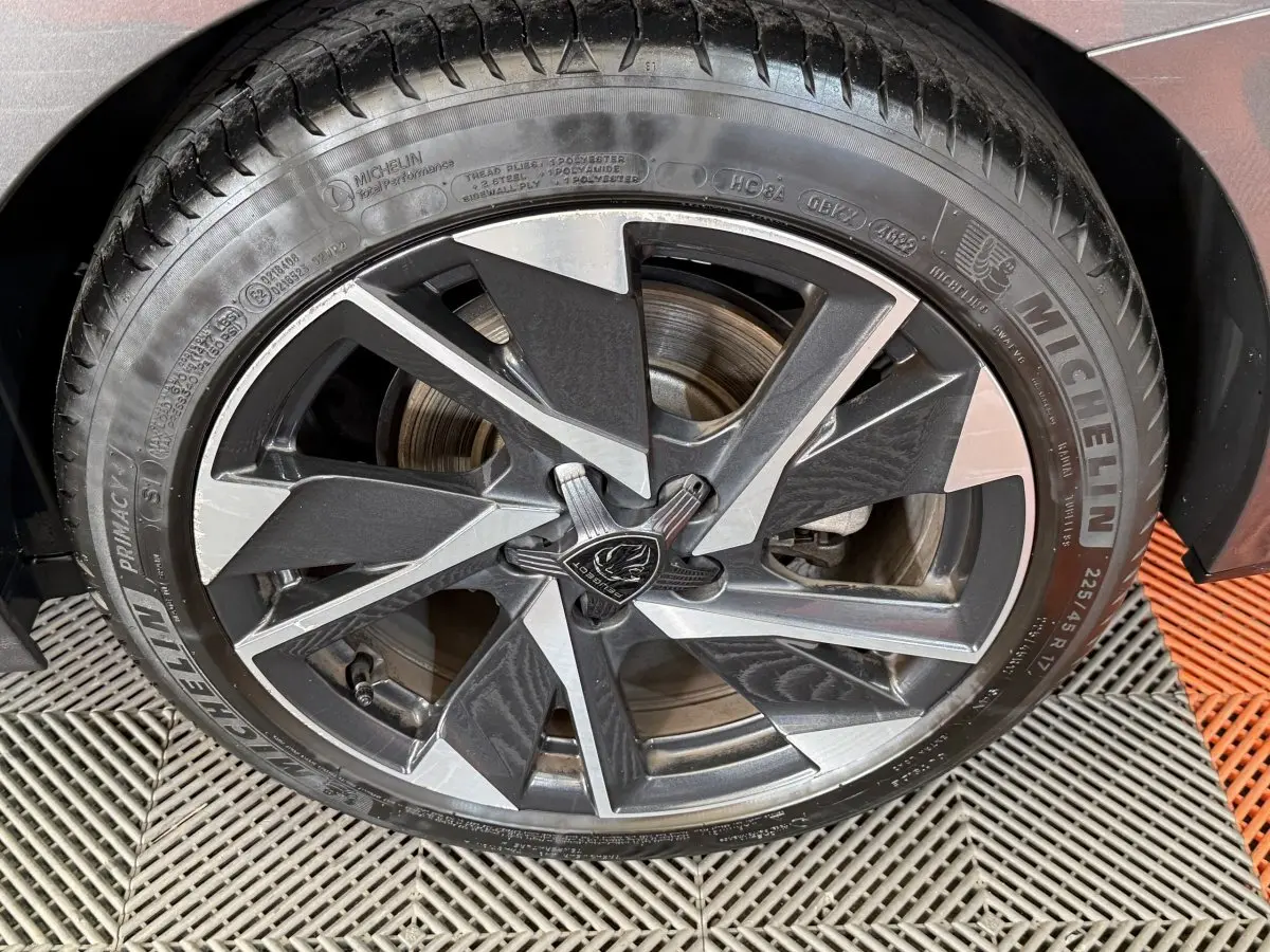 Gros plan sur la jante alliage bicolore noire et argentée de la Peugeot 308 SW gris foncé, pneu Michelin visible.