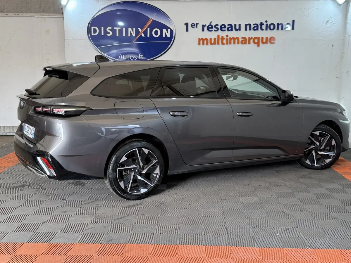 Peugeot 308 SW gris foncé vue de profil côté droit, avec jantes alliage et feux arrière LED distinctifs.