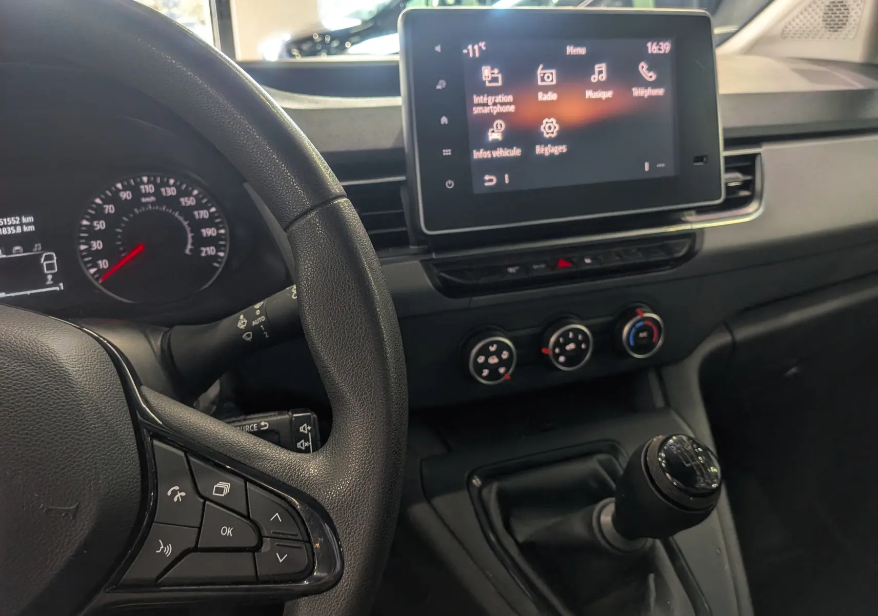 Vue intérieure côté conducteur du Renault Kangoo 2021, montrant le volant, la boîte manuelle et l'écran tactile central.