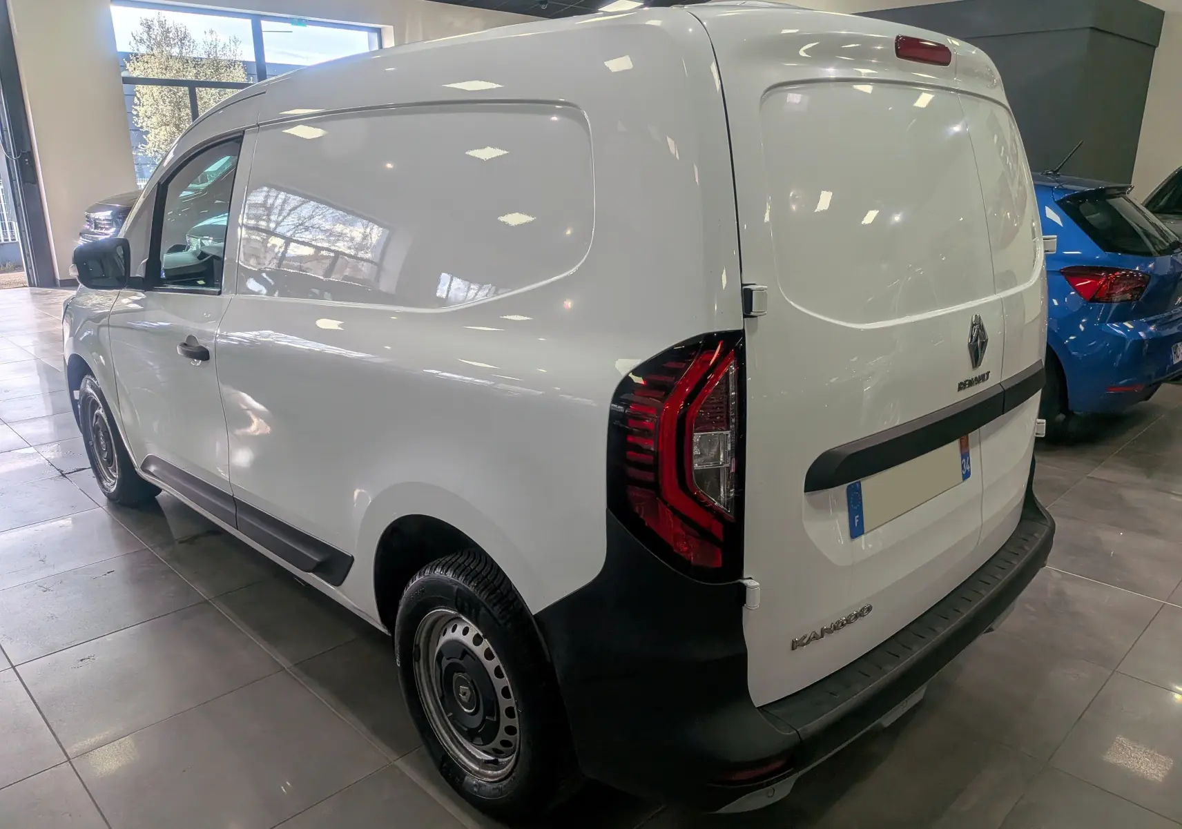 Vue 3/4 arrière droite du Renault Kangoo Van blanc minéral, avec feux arrière rouges et pare-chocs noir mat.
