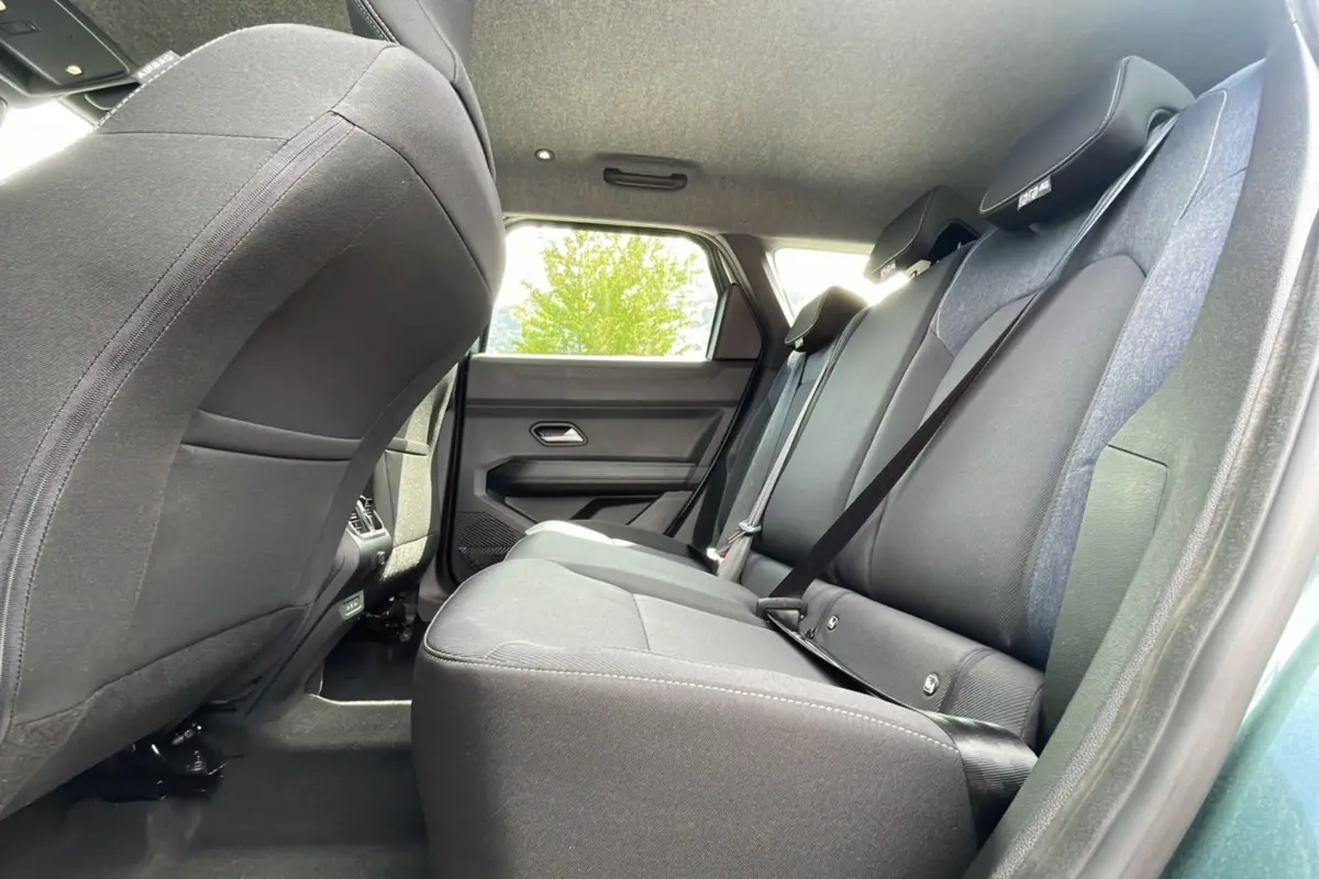 Vue intérieure arrière côté droit du Dacia Bigster 2025, sièges tissu gris et ceinture de sécurité visible.