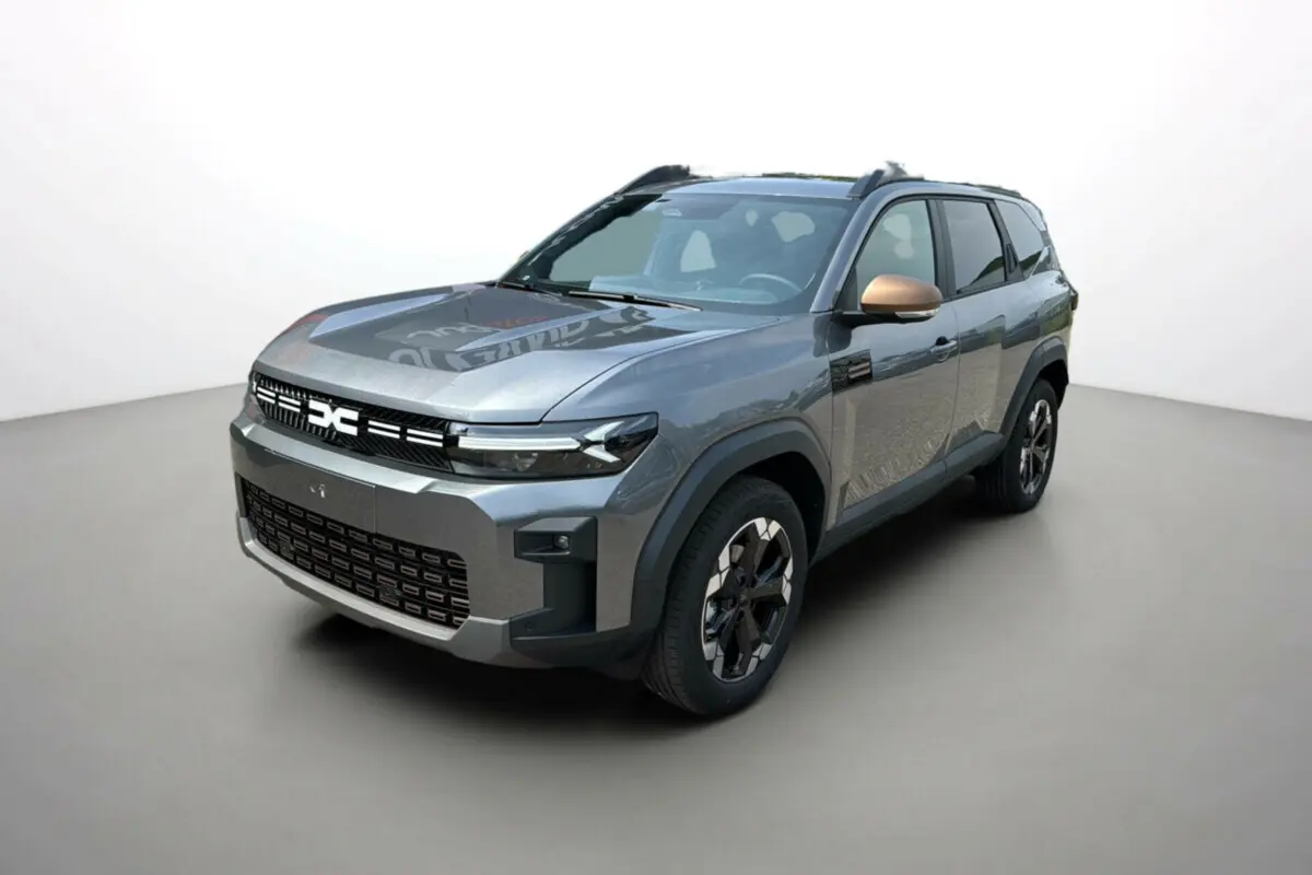 Vue 3/4 avant du Dacia Bigster gris schiste avec rétroviseurs cuivrés et jantes alu 18 pouces distinctives.