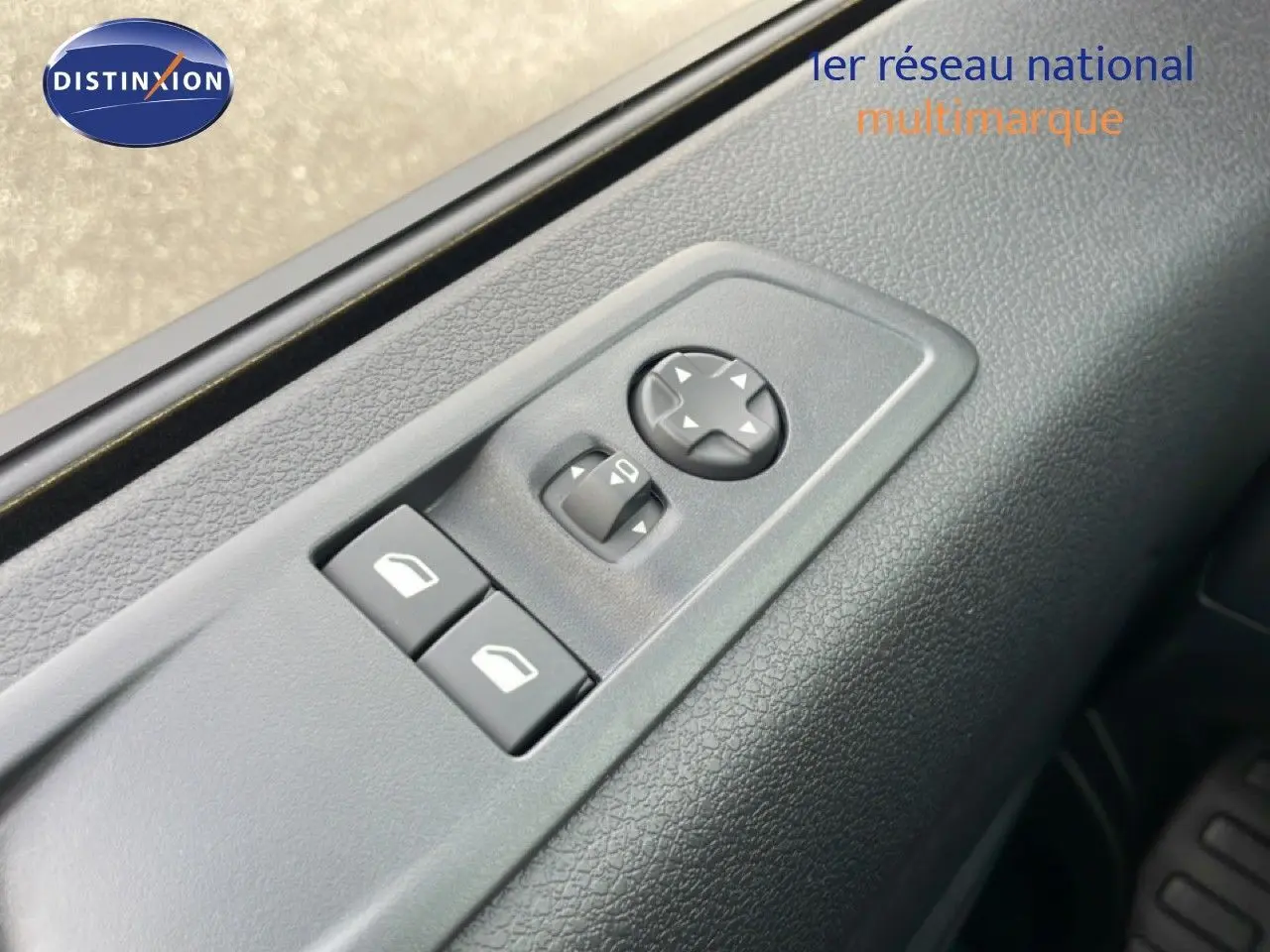 Détail des commandes de réglage des rétroviseurs et vitres sur la porte côté conducteur d’un Citroën Jumpy gris titane.