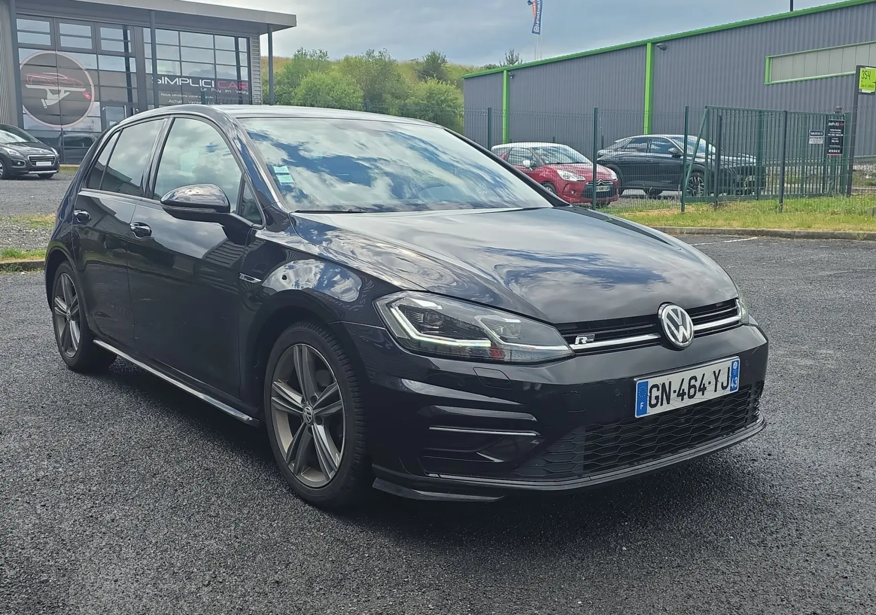 Volkswagen Golf 1.5 TSI EVO 150 R-line noire vue 3/4 avant avec jantes alliage et phares LED allumés.