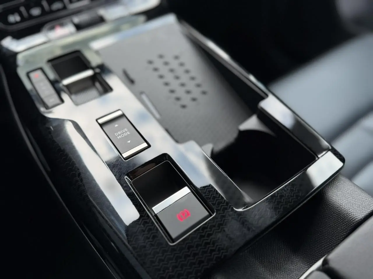 Gros plan sur la console centrale noire brillante du Citroën C5 Aircross avec bouton frein électrique et sélecteur mode conduite.