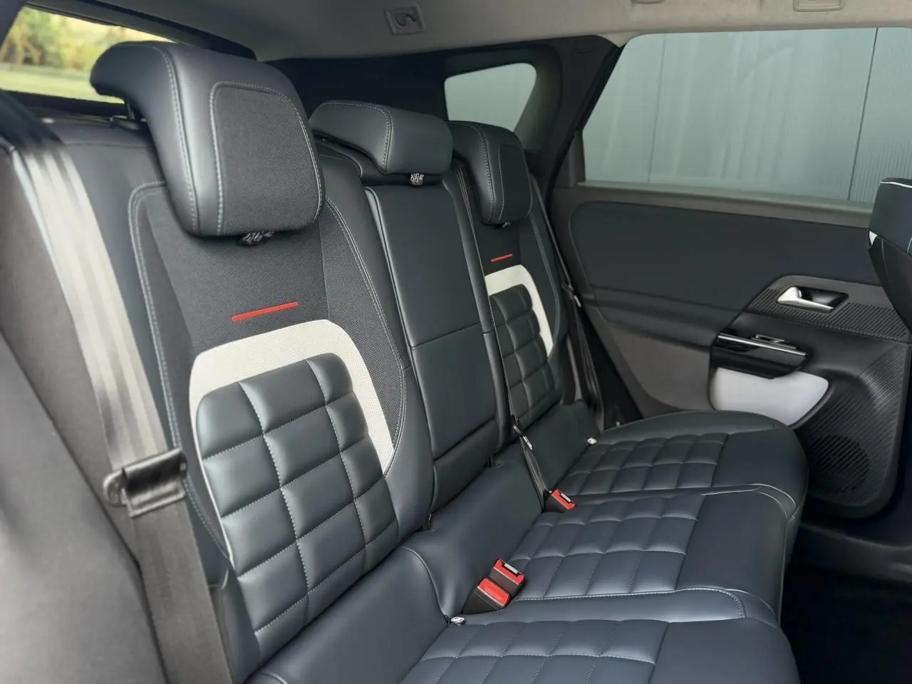 Vue intérieure côté droit des sièges arrière en cuir noir matelassé avec surpiqûres blanches et détails rouges du Citroën C5 Aircross.