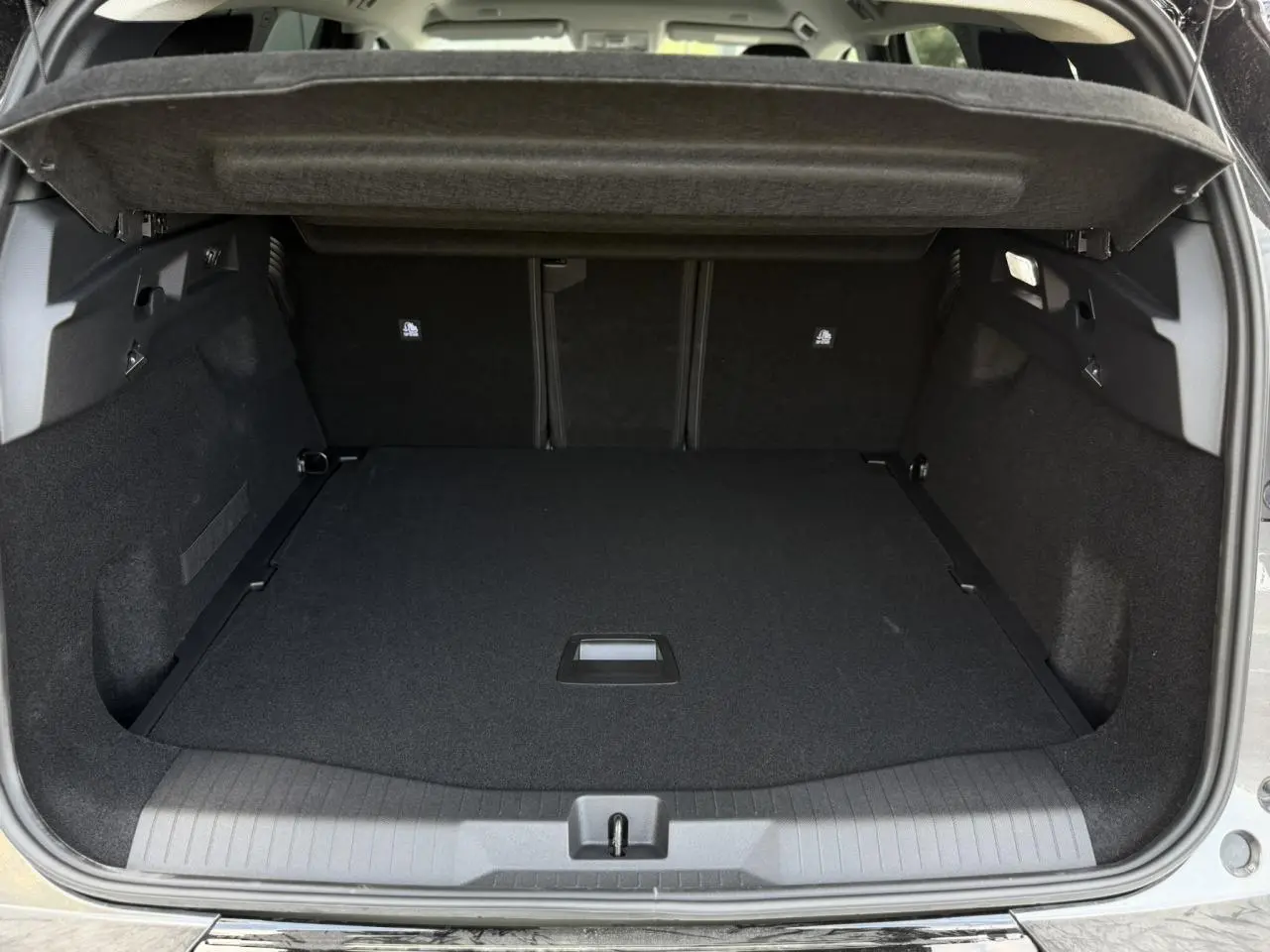 Coffre ouvert vu de l'arrière du Citroën C5 Aircross gris Platinium, montrant un espace de chargement propre et modulable.