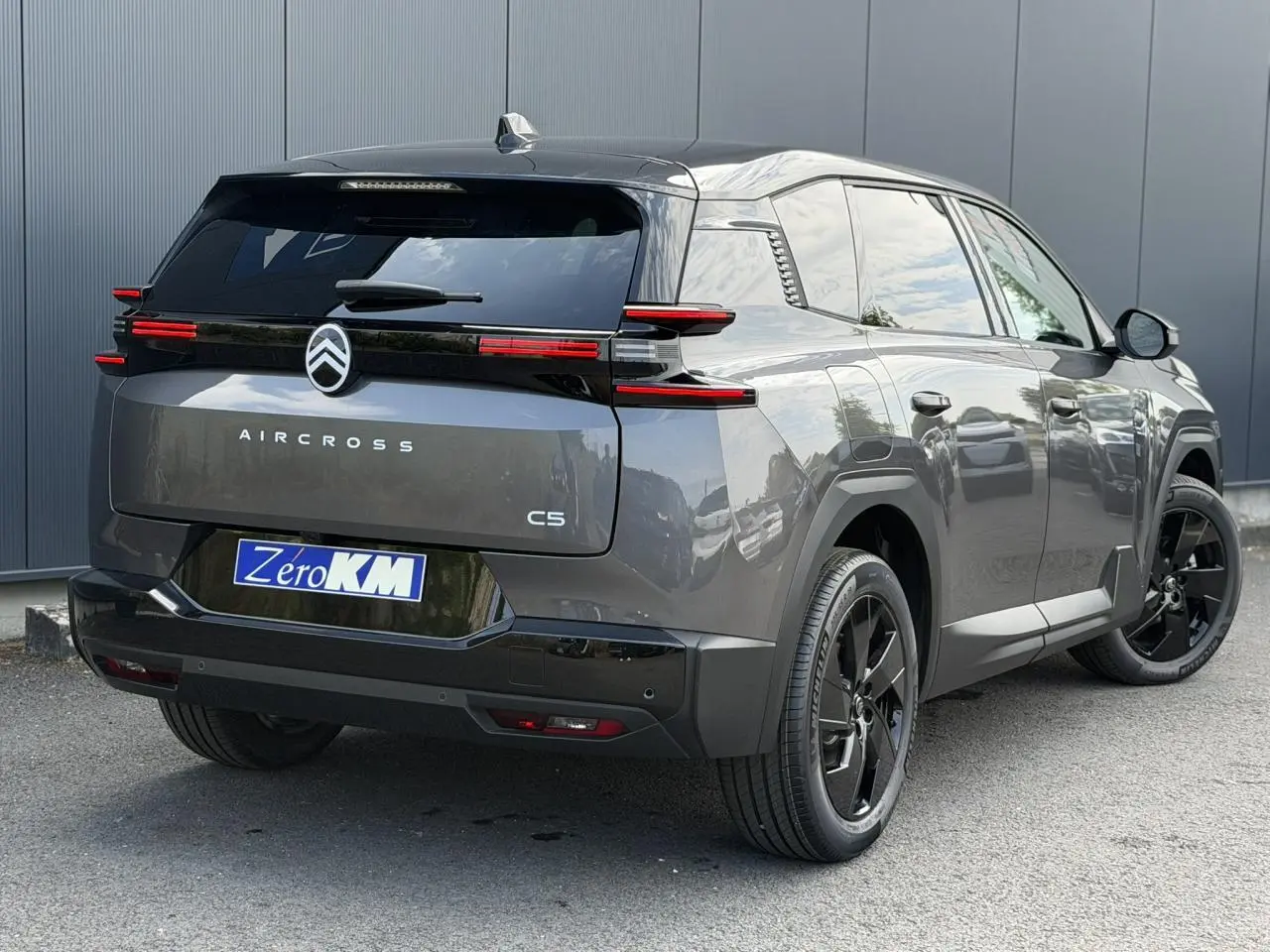 Vue 3/4 arrière droite du Citroën C5 Aircross gris Platinium avec toit noir et feux arrière LED distinctifs.