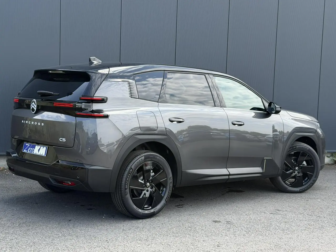 Vue 3/4 arrière droite du Citroën C5 Aircross gris Platinium avec toit noir et jantes alliage noires.