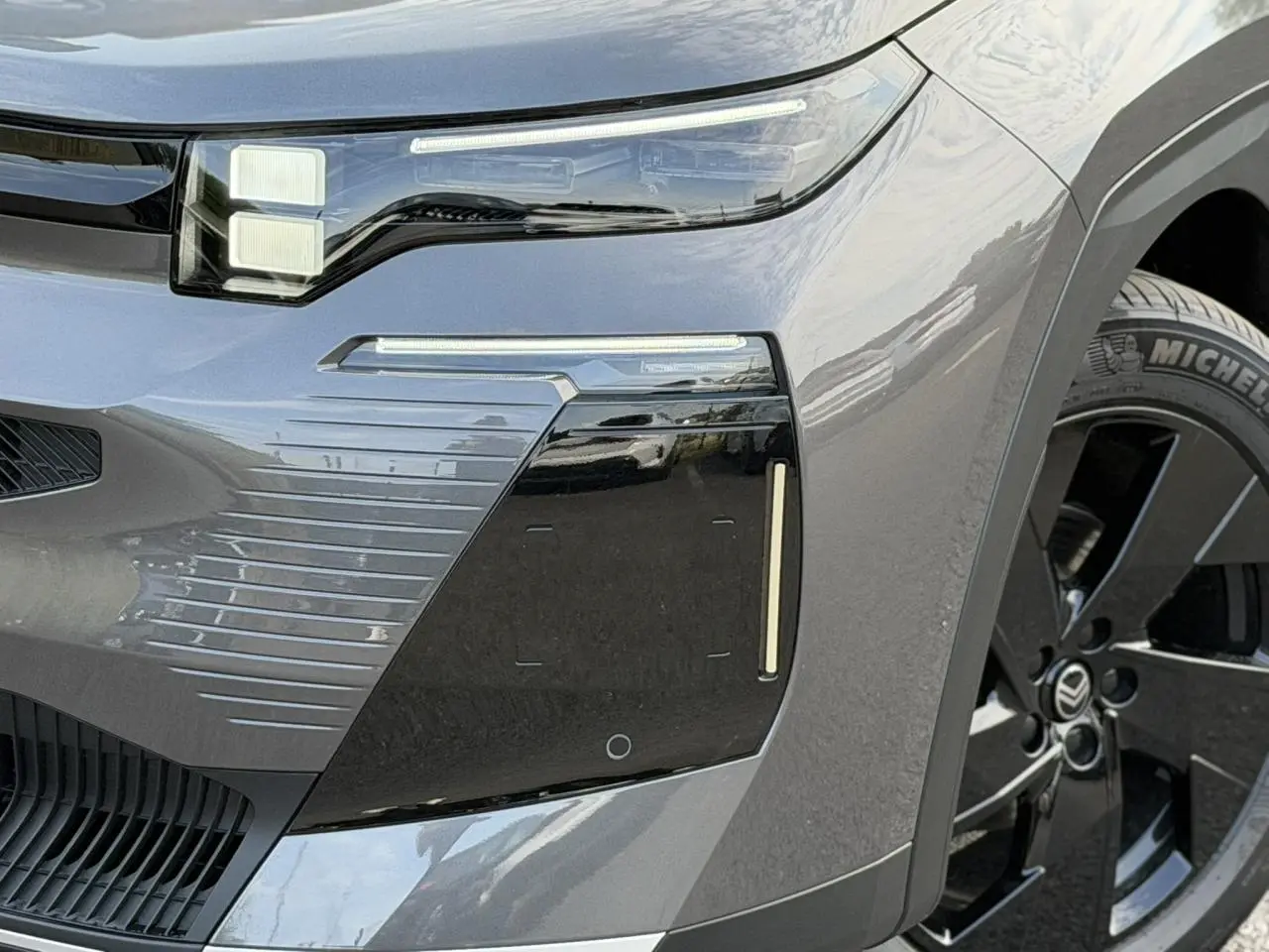 Gros plan avant droit du Citroën C5 Aircross gris Platinium avec détails noirs et jante alliage 19 pouces.