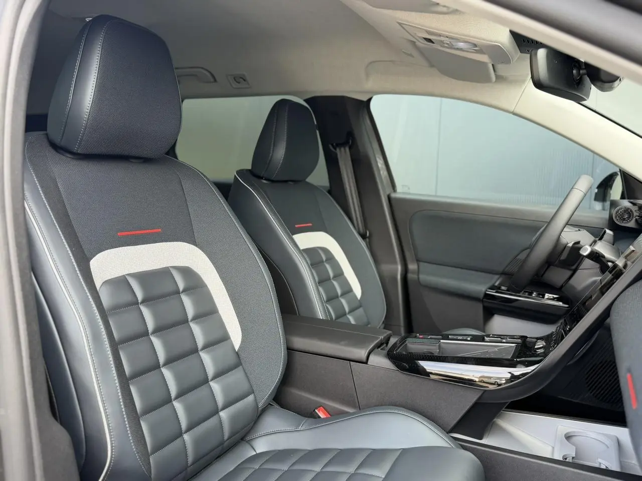 Vue intérieure côté gauche des sièges avant gris foncé avec surpiqûres blanches et inserts noirs matelassés du Citroën C5 Aircross 2026.