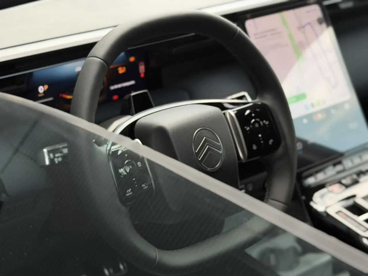Vue rapprochée du volant noir multifonctions de la Citroën C5 Aircross avec écran tactile et affichage numérique.