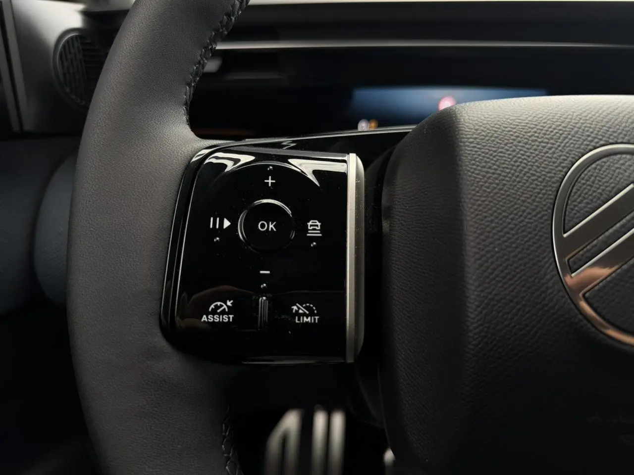 Gros plan sur les commandes noires brillantes au volant cuir noir du Citroën C5 Aircross hybride 2026.
