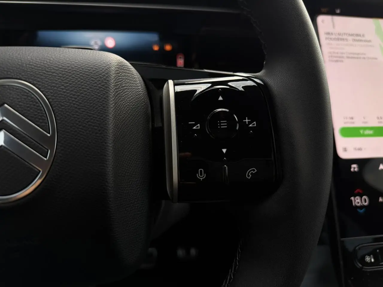 Gros plan sur le volant noir du Citroën C5 Aircross 2026 avec commandes tactiles et logo chromé visible.