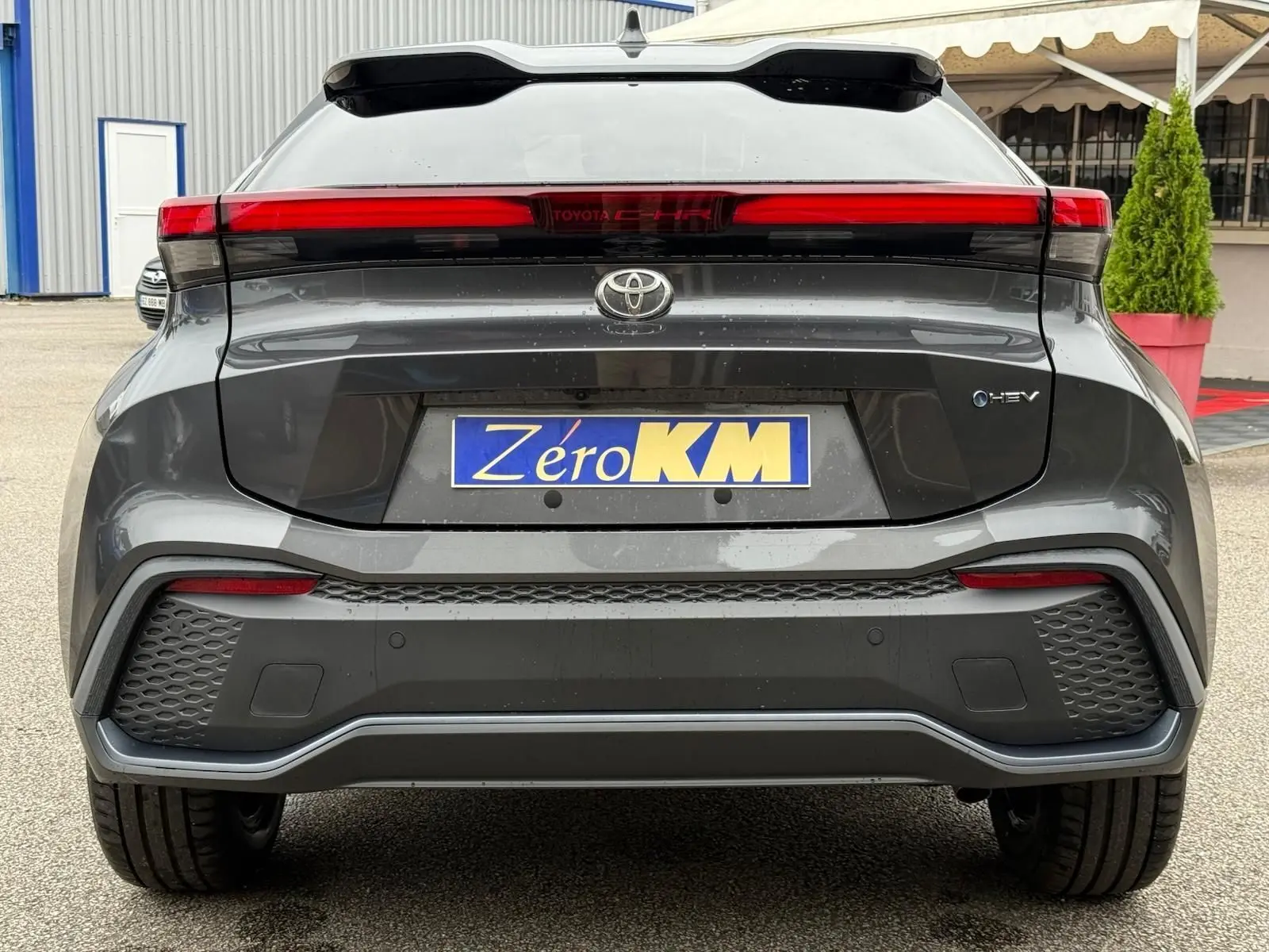 Vue arrière du Toyota C-HR 1.8 140CH STYLE MY25 gris atlas avec feux LED traversants et plaque Zéro KM.