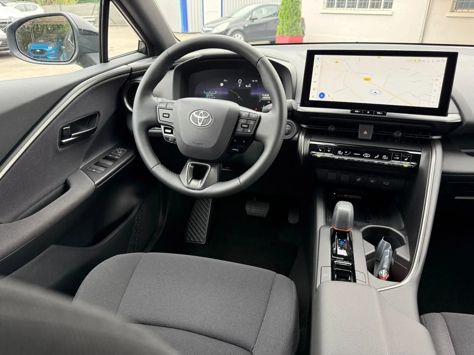 Vue intérieure avant du Toyota C-HR 1.8 140CH STYLE MY25 avec tableau de bord numérique et écran tactile central.