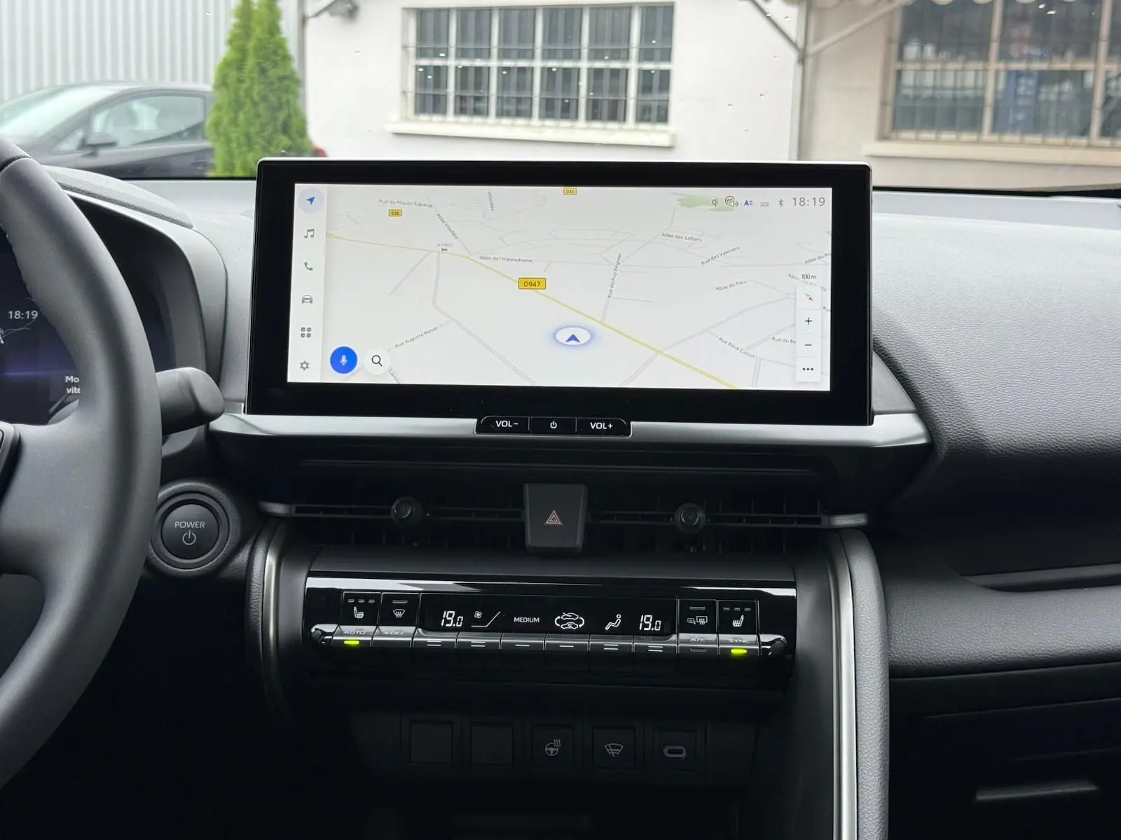 Tableau de bord du Toyota C-HR 1.8 140CH STYLE 2025 avec écran tactile GPS et commandes climatisation affichant 19°C.