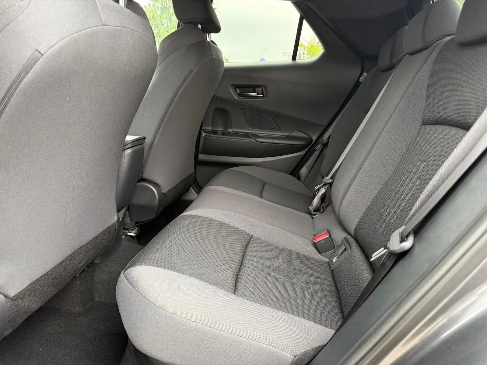 Vue intérieure côté droit des sièges arrière gris foncé du Toyota C-HR 1.8 140CH STYLE MY25, ambiance sobre et moderne.