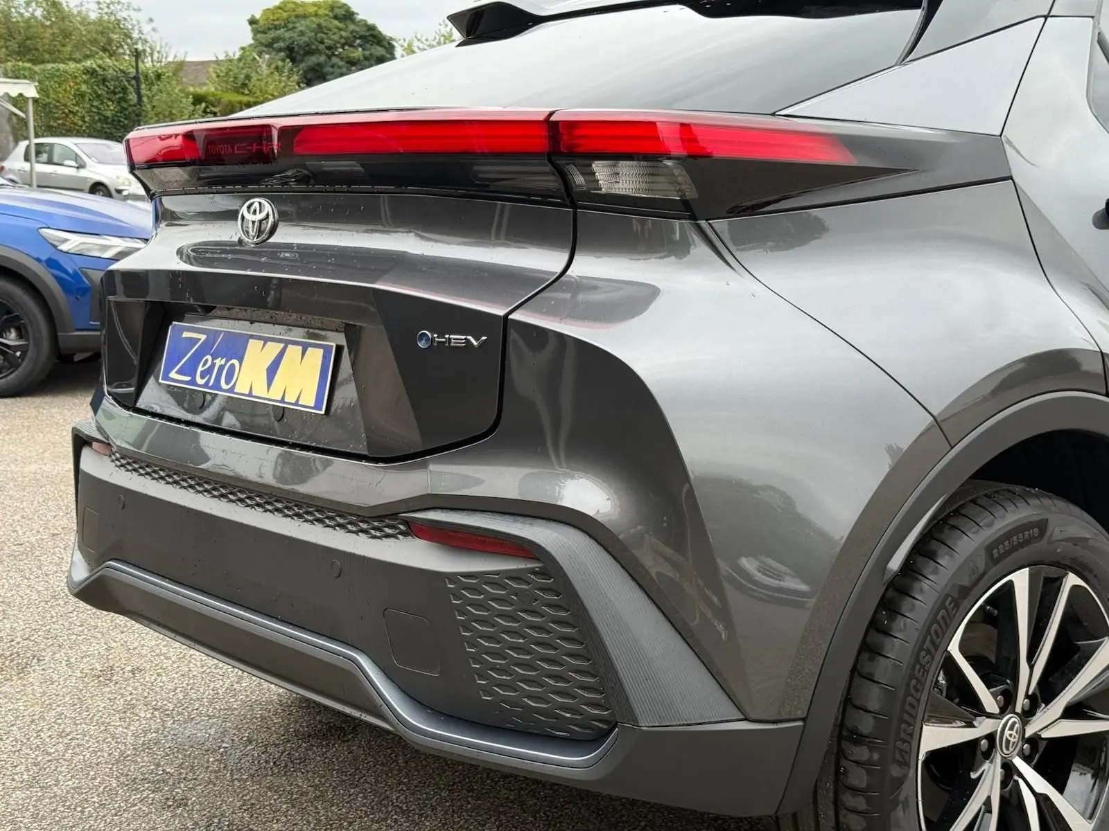 Vue 3/4 arrière droite du Toyota C-HR 1.8 140CH STYLE gris atlas avec feux LED et jantes alliage noires.