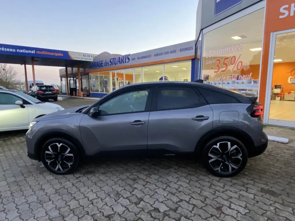 Profil droit d'une Citroën C4 2025 gris foncé avec toit bi-ton noir, jantes stylisées et vitres teintées.