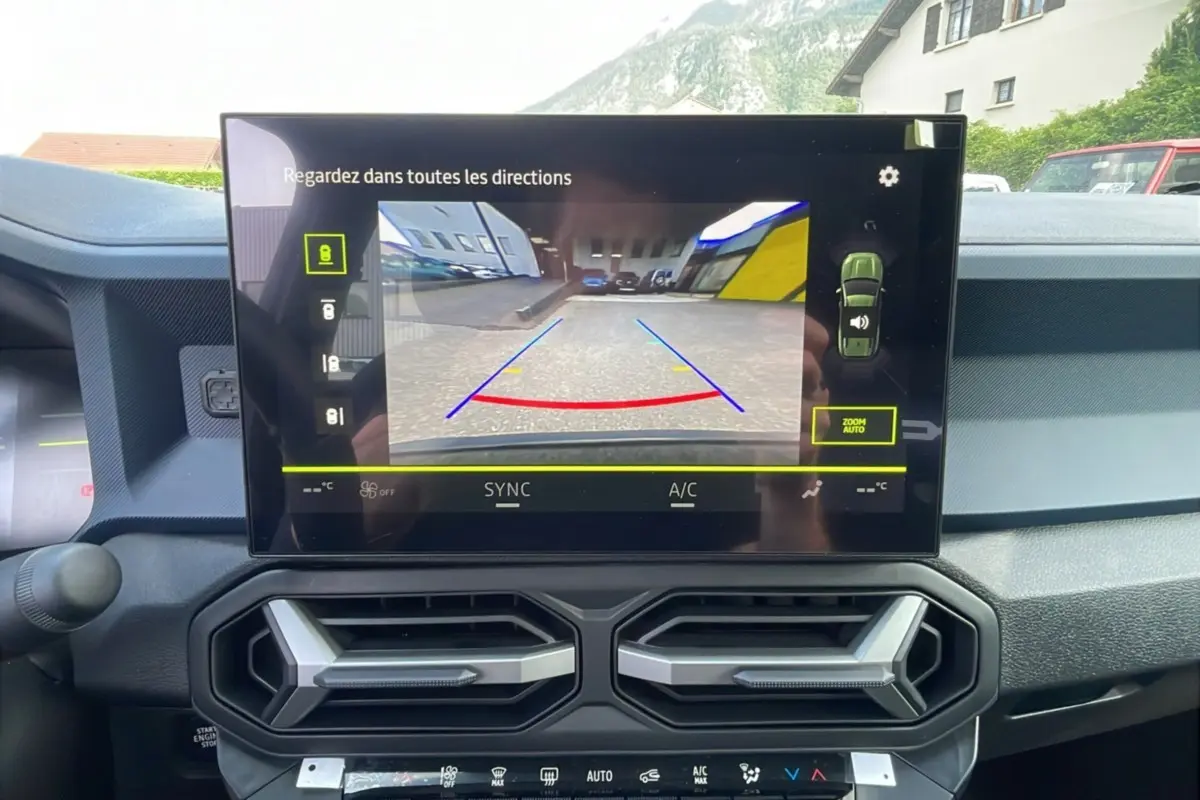 Écran central affichant la caméra multiview du Dacia Bigster, intérieur noir avec aérateurs hexagonaux visibles.
