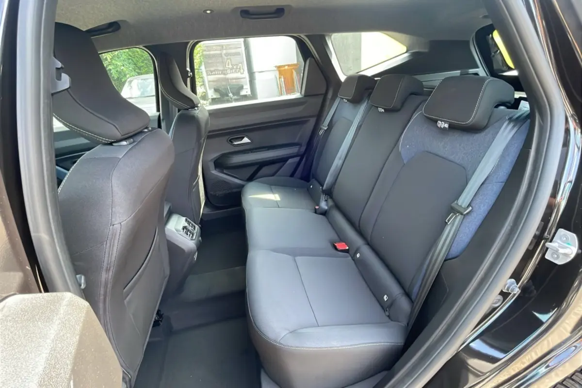 Vue intérieure côté droit sur la banquette arrière noire et grise du Dacia Bigster noir perle 2025, avec ceintures et appuie-têtes.