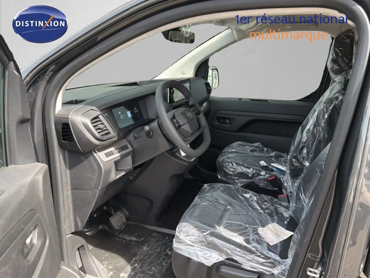 Vue intérieure côté conducteur du Citroën Jumpy Cabine Approfondie gris titane, sièges protégés par film plastique.