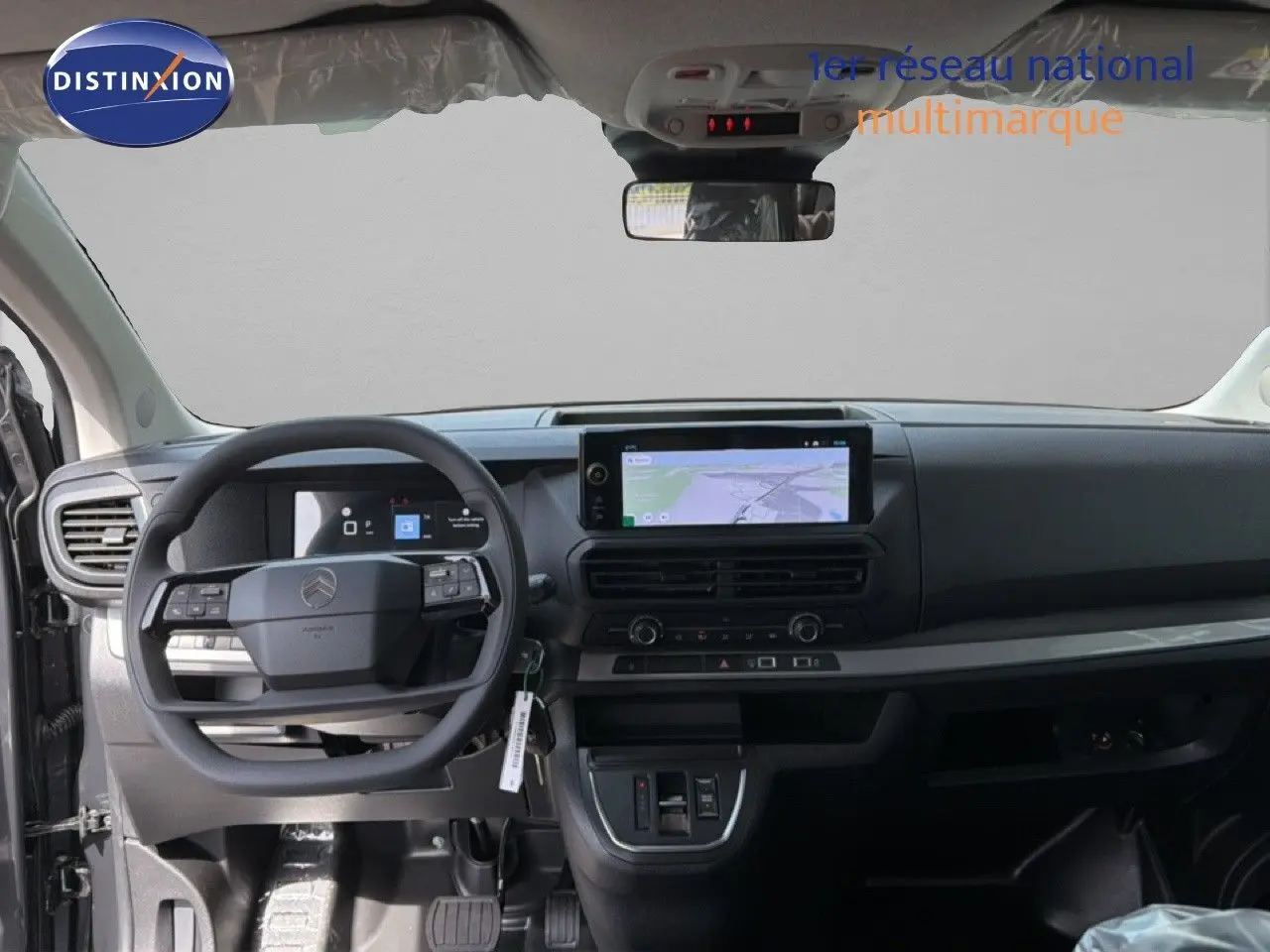 Vue intérieure frontale du tableau de bord et volant du Citroën Jumpy Cabine Approfondie gris titane, avec écran tactile GPS intégré.