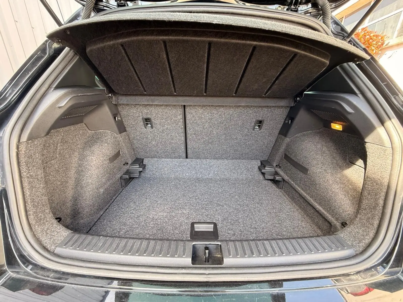 Coffre ouvert vu de l'arrière d'une SEAT Arona 2022 noire, avec intérieur gris et éclairage latéral allumé.