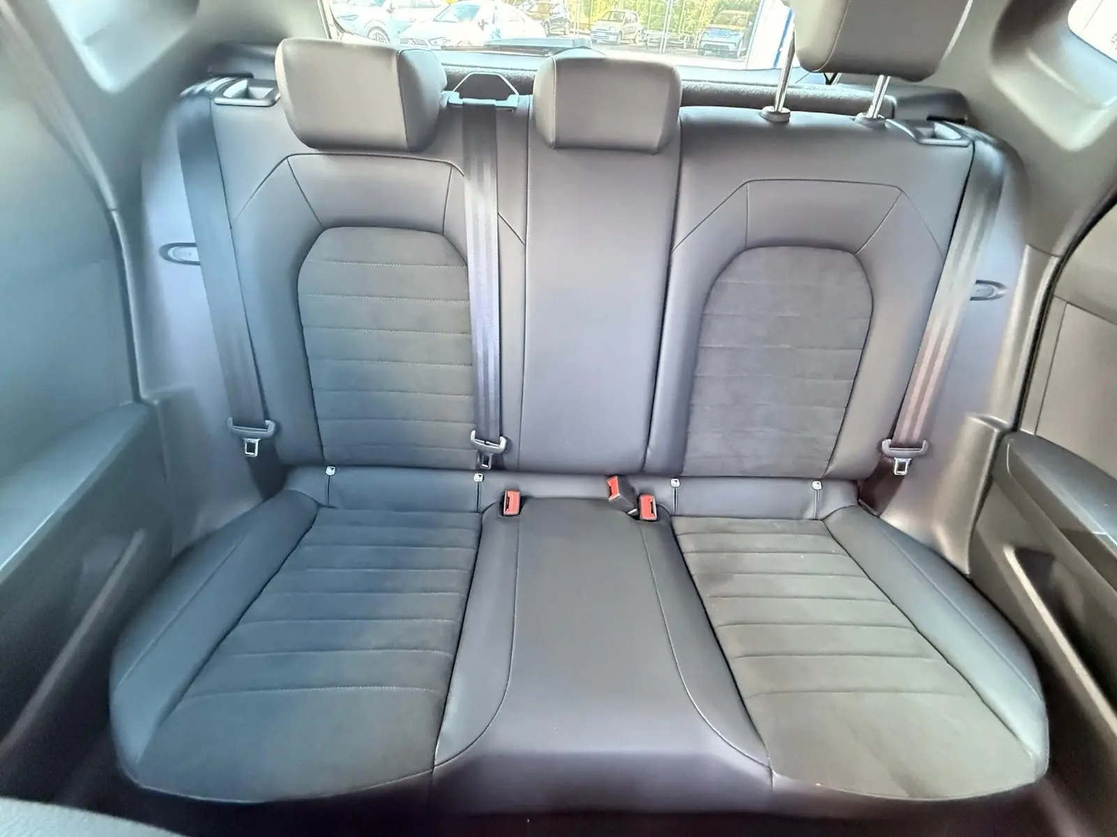 Banquette arrière noire vue de face dans une SEAT Arona 2022 avec ceintures et appuie-têtes intégrés.