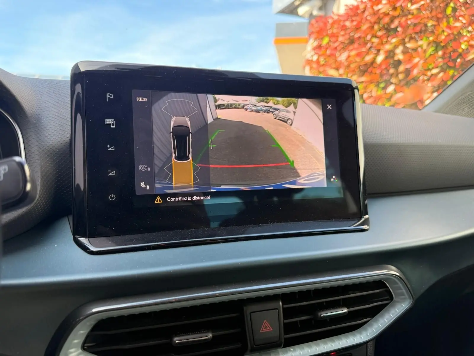 Écran tactile intérieur montrant la caméra de recul du SEAT Arona, vue arrière avec repères de stationnement colorés.