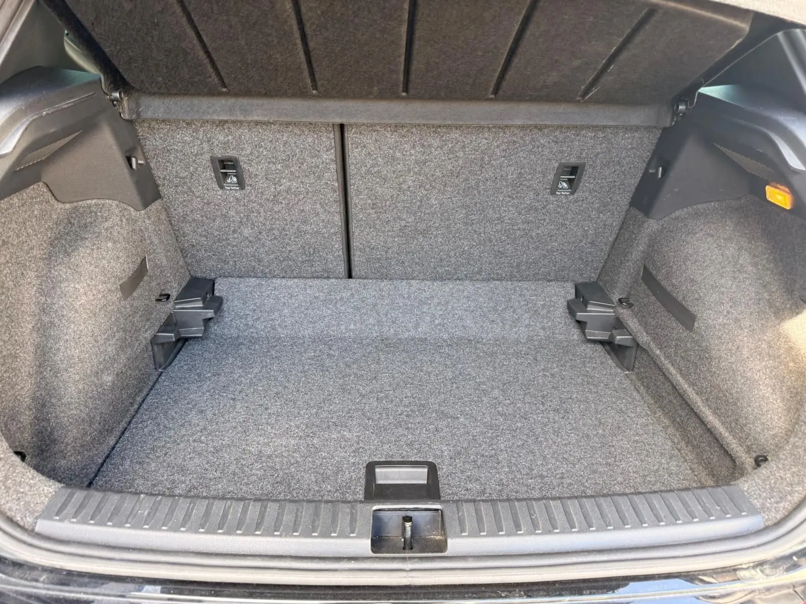 Vue intérieure du coffre gris du SEAT Arona 2022, montrant l'espace de rangement et la moquette intégrale.