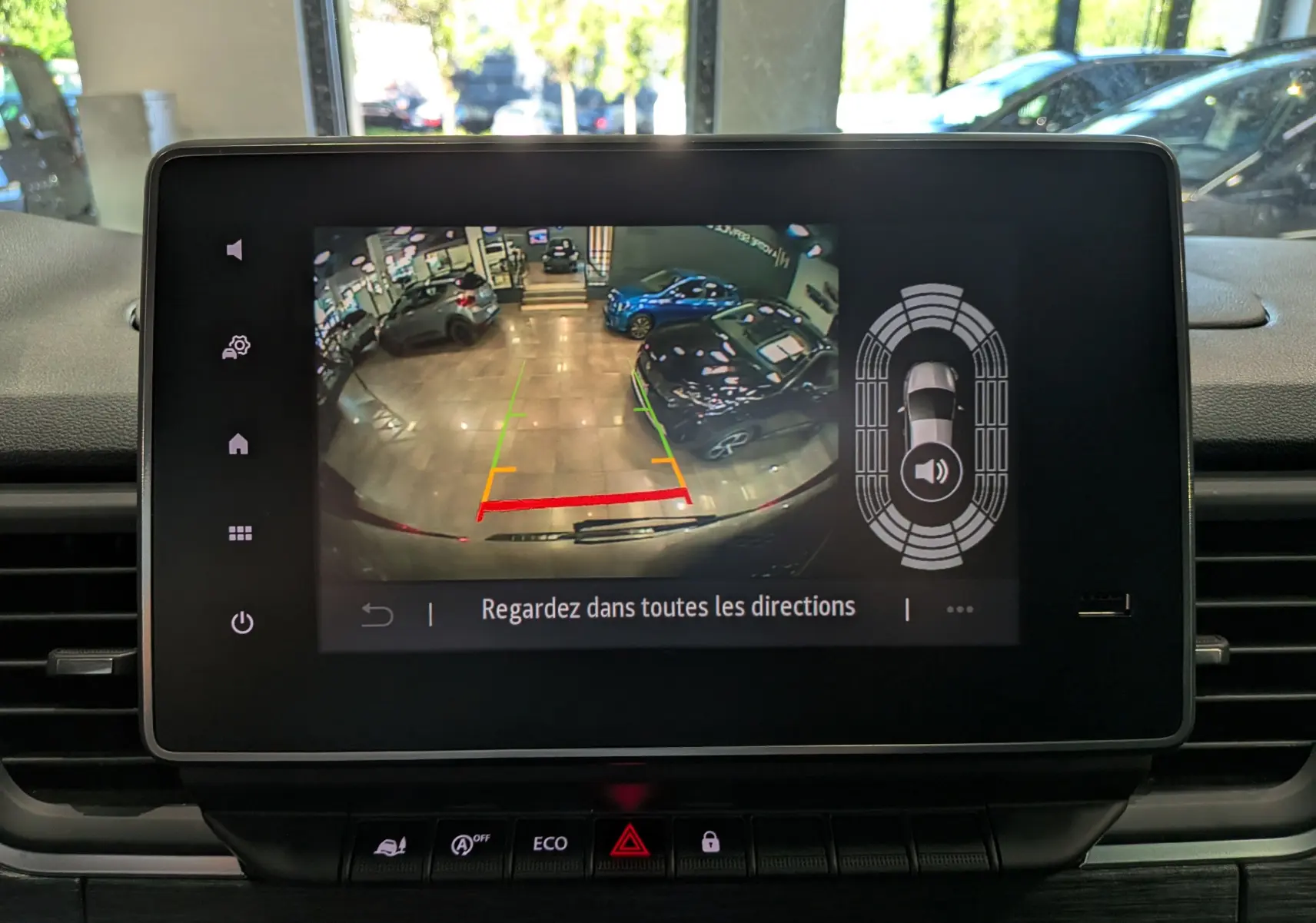 Écran de caméra de recul du Nissan Primastar Combi gris Comète, vue intérieure du tableau de bord avec aide au stationnement.
