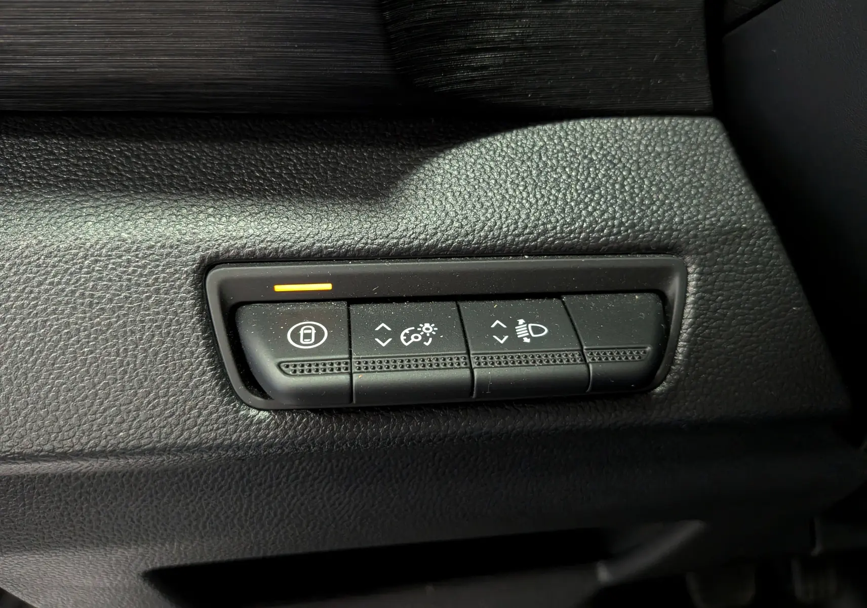 Gros plan sur les commandes de réglage d'éclairage et verrouillage intérieur du Nissan Primastar Combi gris, côté conducteur.